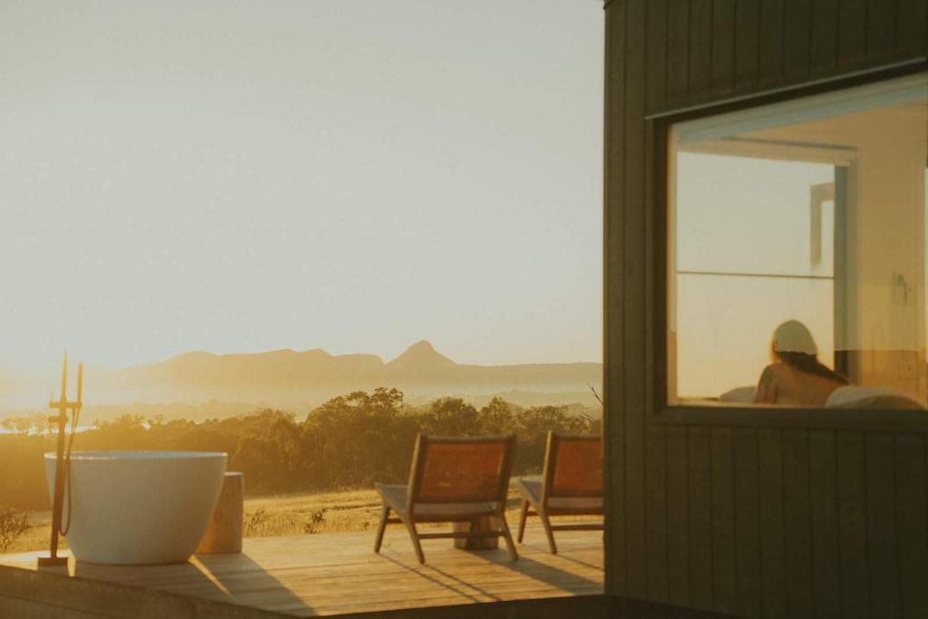 a person sitting on a porch looking out of a window at Tiny Harry in Mudgee