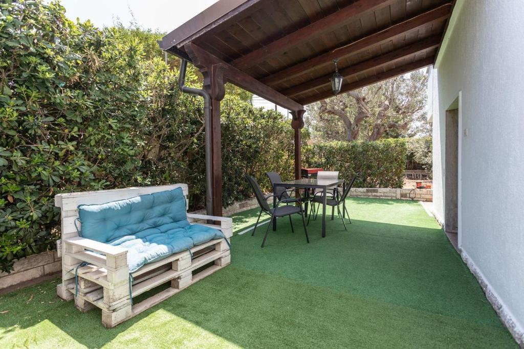 トッレ・スーダにあるVilla Miranda - Salento Reservationの木製パーゴラ、テーブル、椅子付きのパティオ