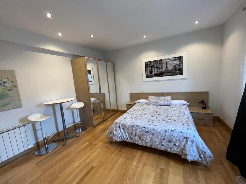 a bedroom with a bed and two stools in it at Estudios Blanmart in Santander