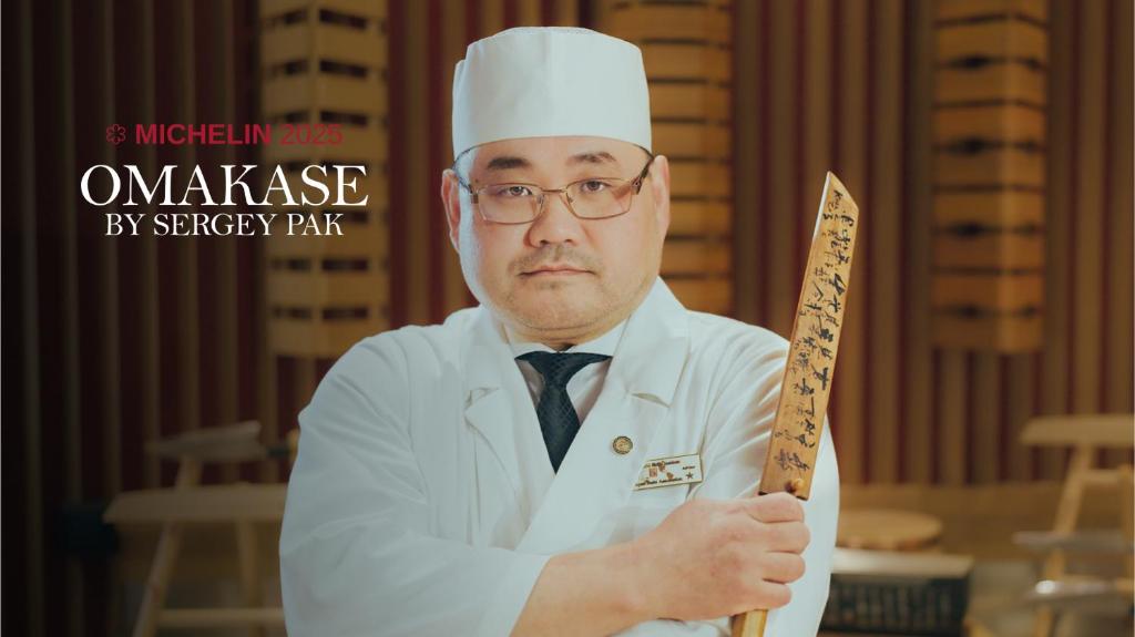 a man in a chefs hat holding a knife at Skostredet Hotel in Bergen