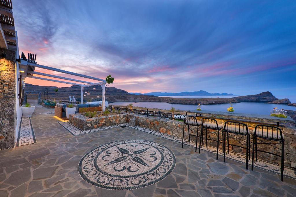 a patio with a view of a body of water at Lindos Vigli Private Villa in Lindos