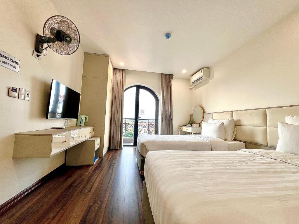 Postel nebo postele na pokoji v ubytování Grand Dragon Noi Bai Hotel