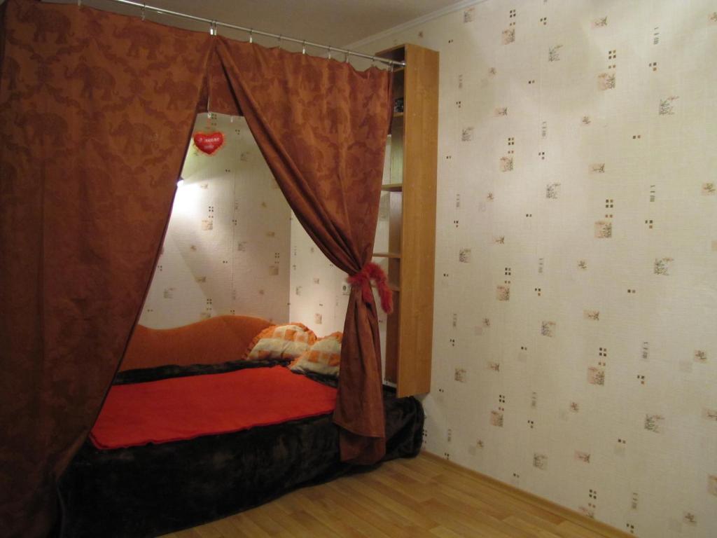 a bed in a room with a curtain at A comfortable 18m room with balcony in Tallinn