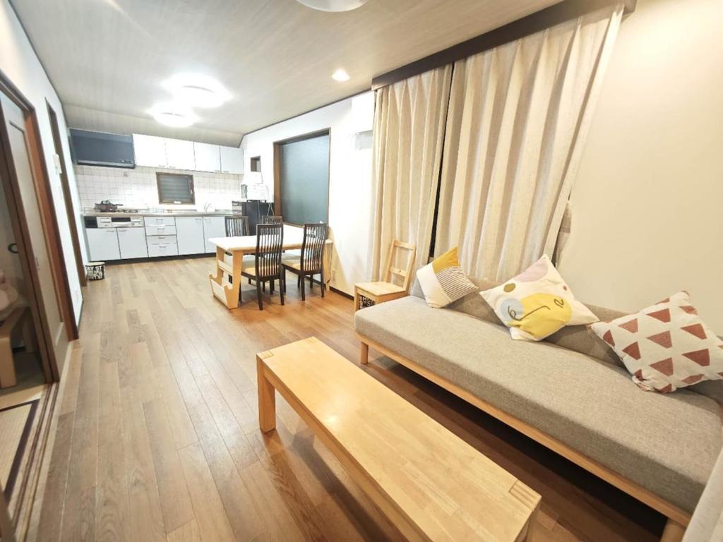 a living room with a couch and a table at ZYZ Fujimidai House練馬一户建 in Tokyo