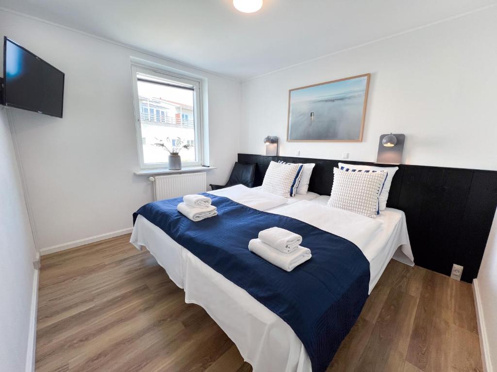 a bedroom with a large bed with two towels on it at Hotel Frederikshavn in Frederikshavn