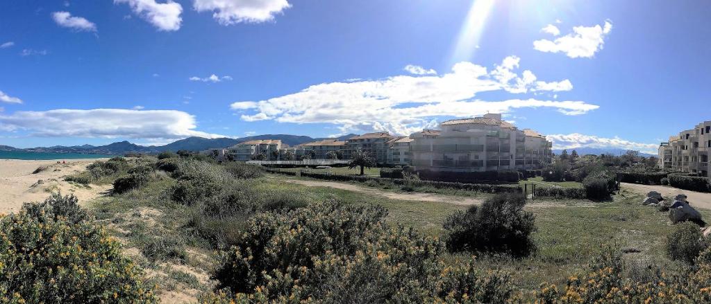 vistas a una playa con edificios y al sol en Résidence Les Goélettes, en Saint Cyprien Plage