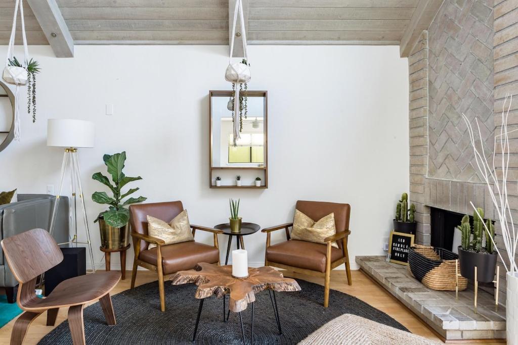 a living room with chairs and a table and a fireplace at Silver Triangle Oasis with Verdant Backyard in Los Angeles