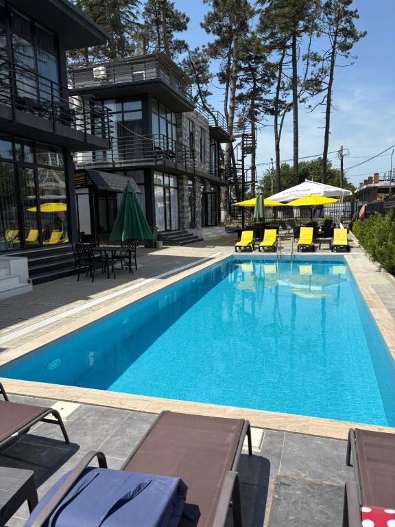 a swimming pool with chairs and umbrellas next to a building at Blue Horizon Apartments in Ureki