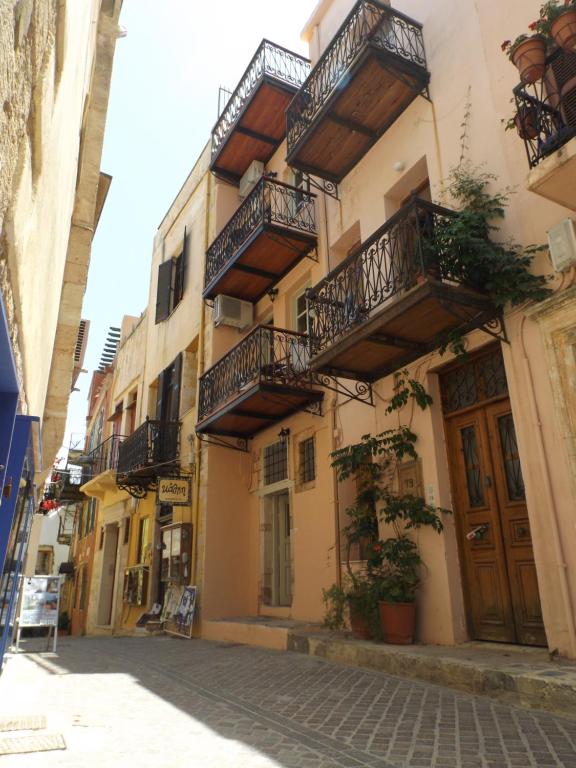 een gebouw met balkons aan de straatkant bij Fivos Pension in Chania