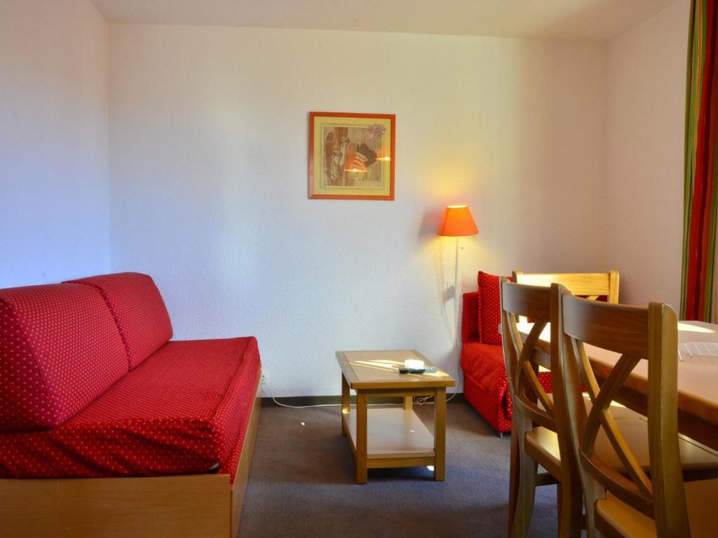 un salon avec un canapé rouge et une table dans l'établissement Appartement 2 pièces cabine pour 6 avec balcons et parking à Montchavin - FR-1-329-8, à Bellentre