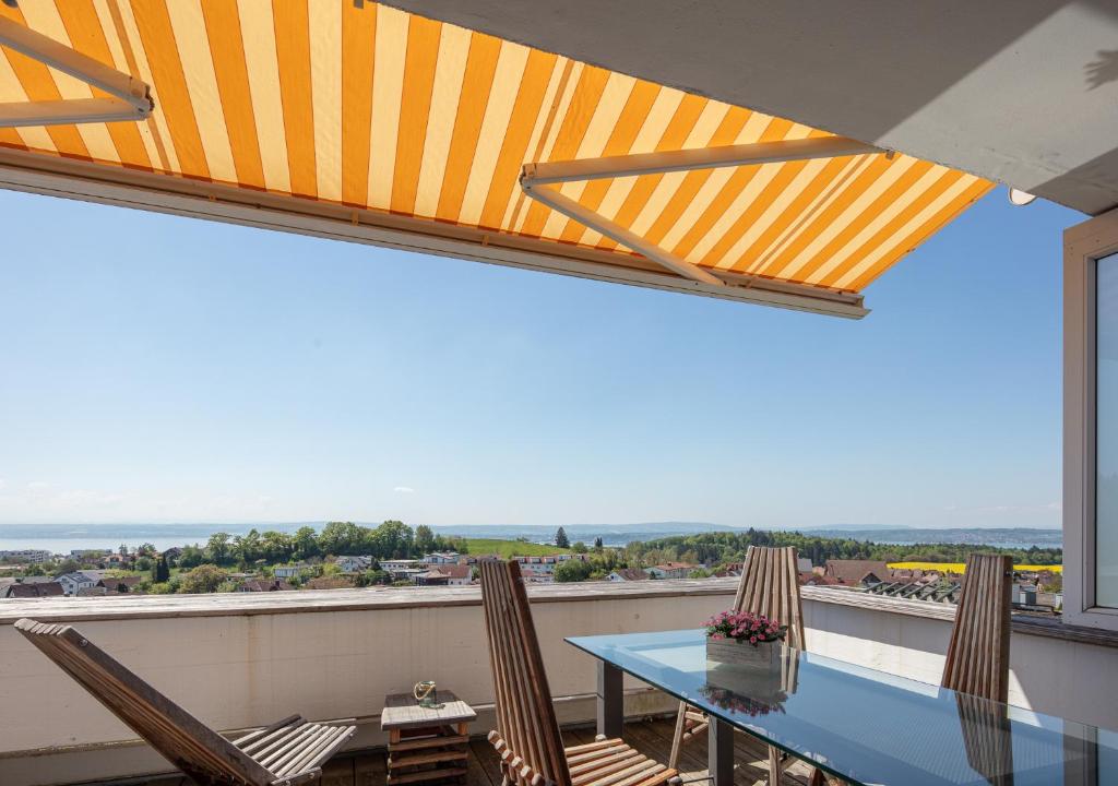 Una mesa y sillas en un balcón con vista. en Ferienwohnung Alpenfeuer, en Daisendorf