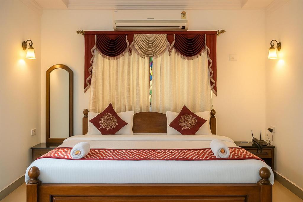 a bedroom with a large bed with a window at Sonikas Holiday Homes (Studio) in Candolim