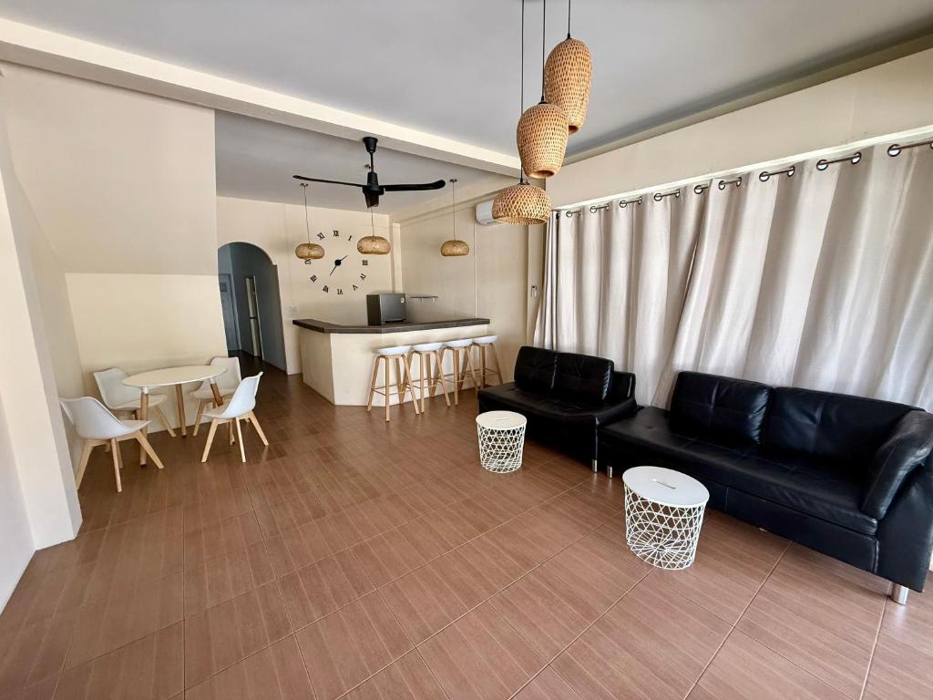 een woonkamer met een zwarte bank en een tafel bij Oh Town Villa in Thongsala