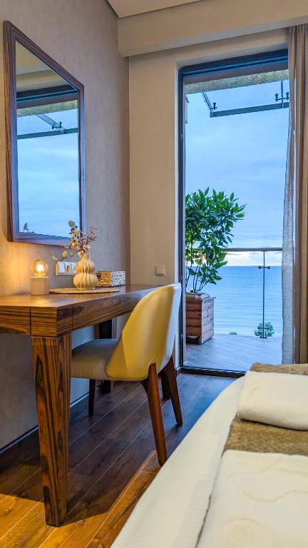 a bedroom with a desk with a yellow chair and a window at Luxury Dreamland Oasis Apartments in Chakvi