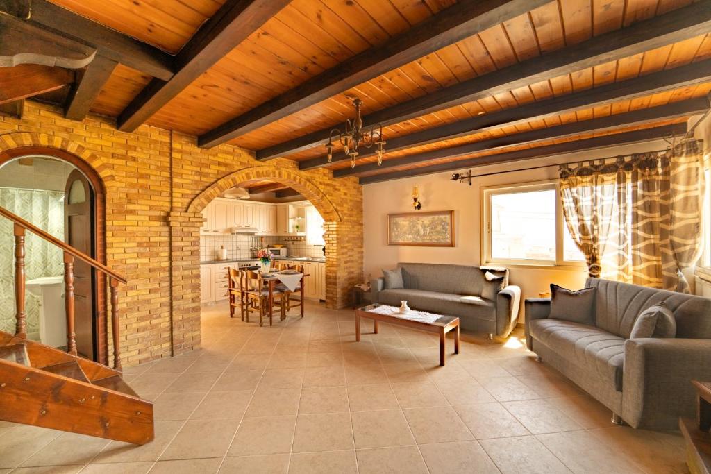 a living room with two couches and a brick wall at Popolaros Traditional House in Zakynthos