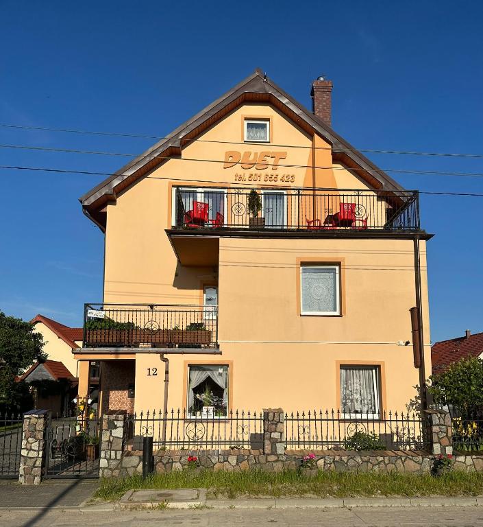 a large yellow building with a sign on it at Duet in Władysławowo