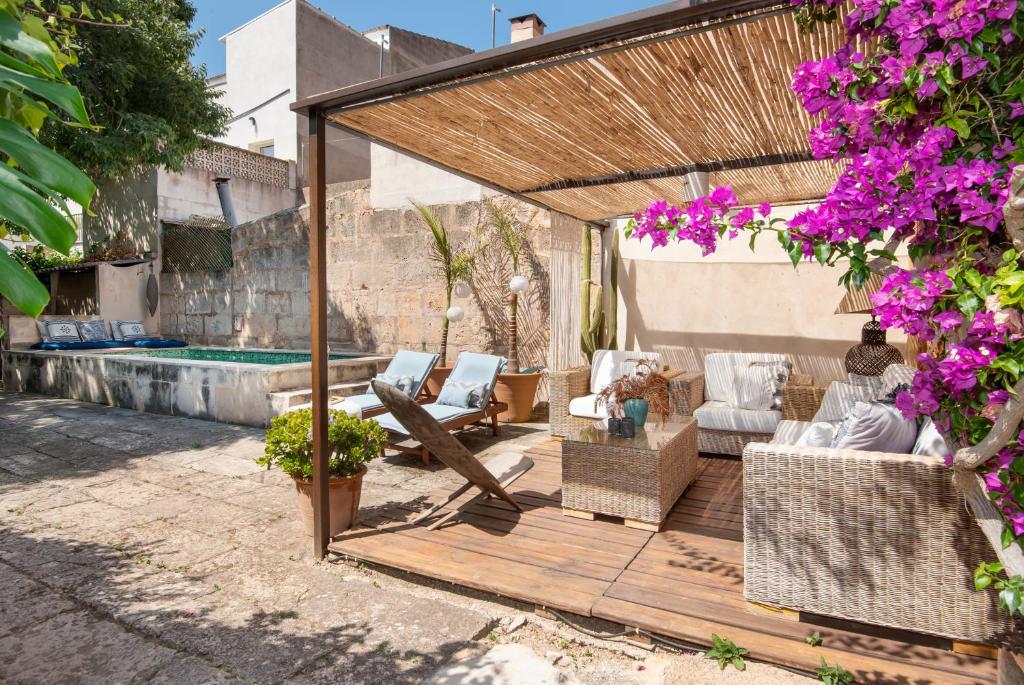 a wooden pergola with chairs and a pool at Ca Na Mon in Ses Salines