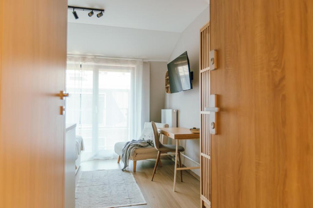 una stanza con una scrivania e un tavolo con una sedia di Kątowa Studio - Sauna, AC, balcony a Cracovia