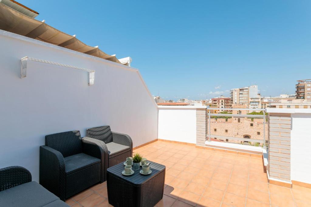 a living room with a couch and chairs on a balcony at Entre Castillo y Mar in Santa Pola