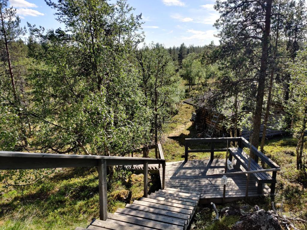 a wooden boardwalk in a forest with trees at Kivakko Saariselän paratiisi - Oma ranta & sauna in Saariselka