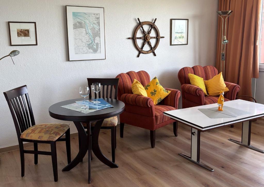 salon z 2 krzesłami, stołem i krzesłami w obiekcie Tief 10 Strandkieker Meerblick 1102 w mieście Wangerland