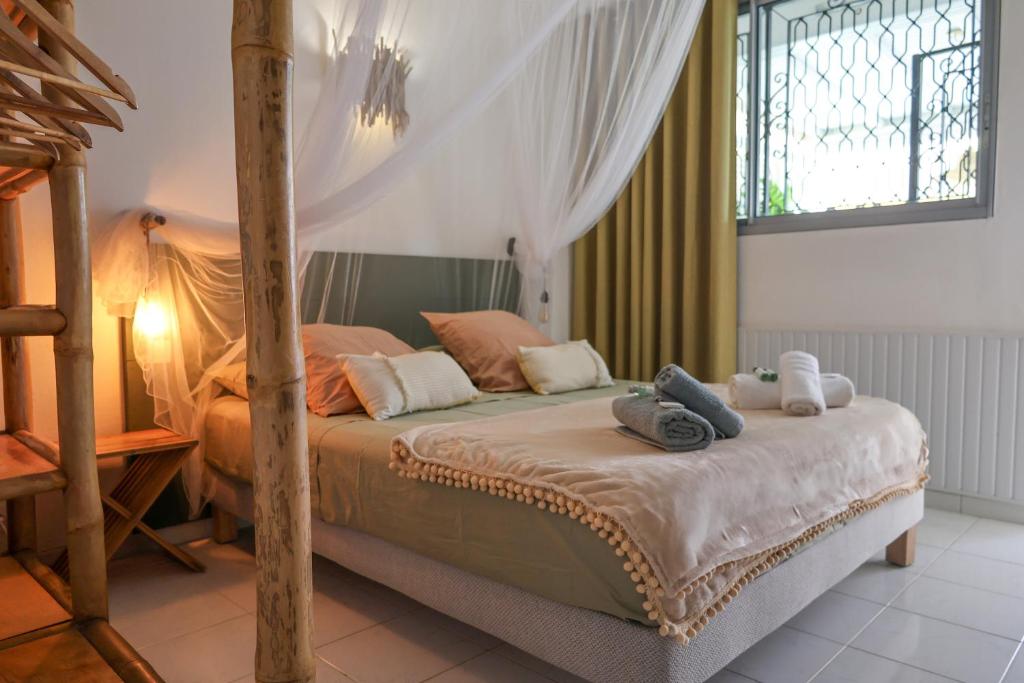 Postel nebo postele na pokoji v ubytování Sur la plage coco, au bord du lagon de Ste Anne