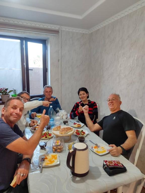 a group of people sitting around a table eating food at Guest House NAZIRA in Kazarman