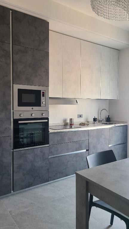 a kitchen with stainless steel appliances and a table at Onda Blu in Rimini