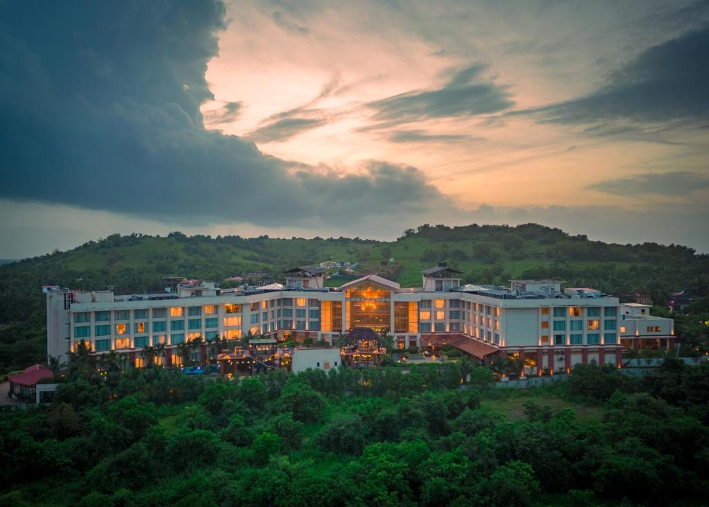 a large hotel with a sunset in the background at The Westin Goa in Vagator