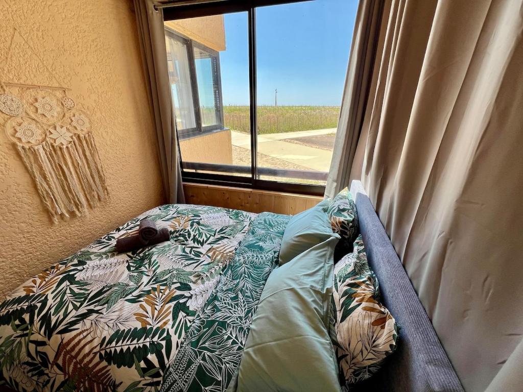 a bed in a room with a window at Evasion cosy aux pieds de l'Océan in Lacanau