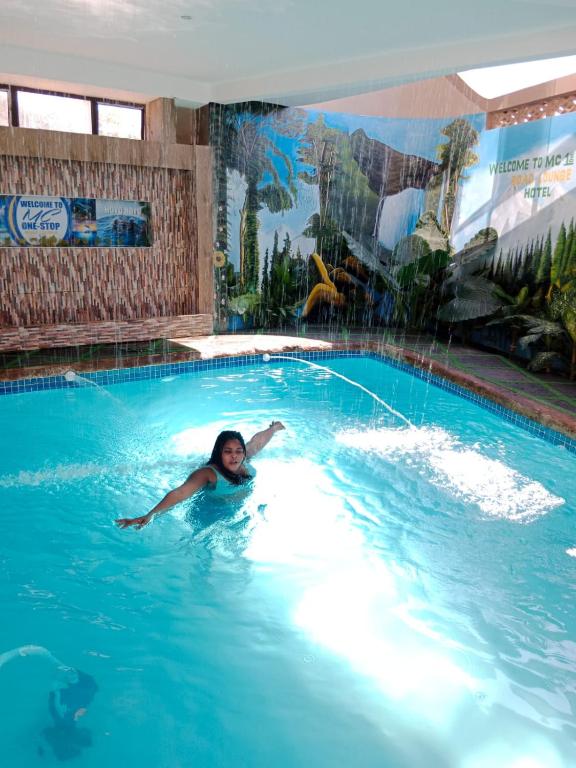 a woman is swimming in a swimming pool at MC One Stop Road Lounge Hotel in Xai-Xai
