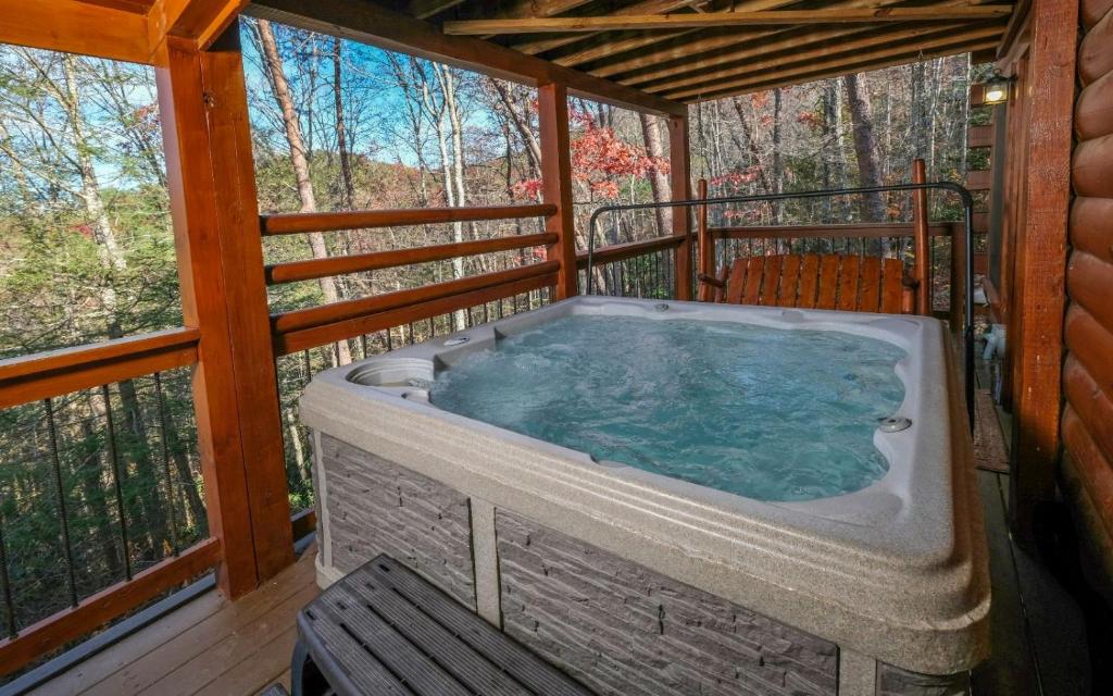 a jacuzzi tub on the back porch of a cabin at Tennessee Treasure in Pigeon Forge