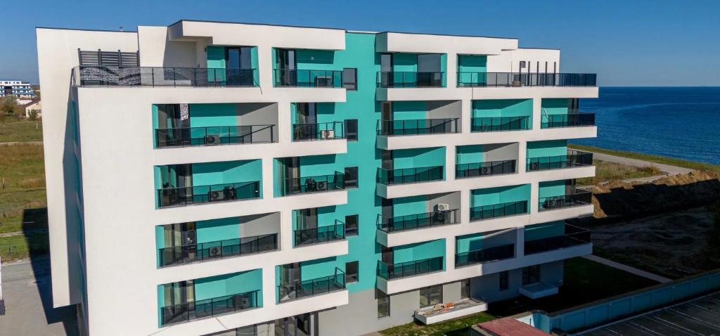 an apartment building with balconies overlooking the ocean at Răsărit la epava in Costinesti
