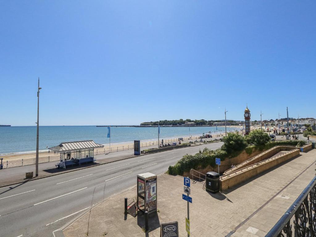 an empty road next to a beach with the ocean at Vista Mare 1 in Weymouth