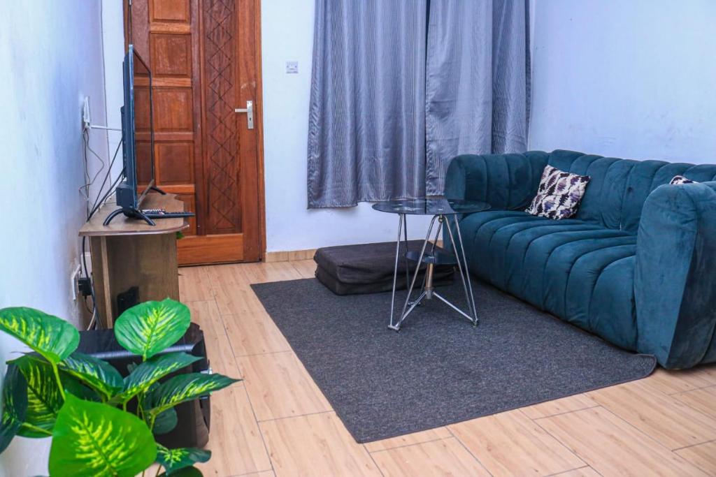 a living room with a blue couch and a television at CASEY APARTMENT ,2Mins TO JCC BAMBURI MTAMBO in Mombasa