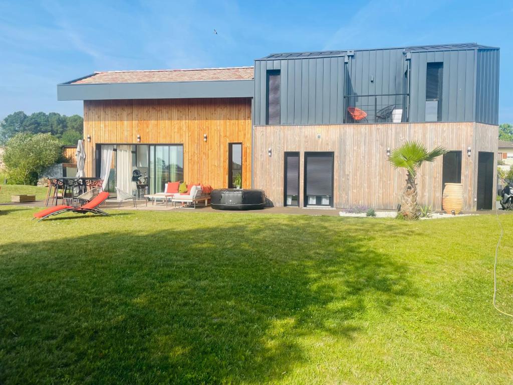 une maison avec une pelouse devant dans l'établissement Villa 7, à Martillac