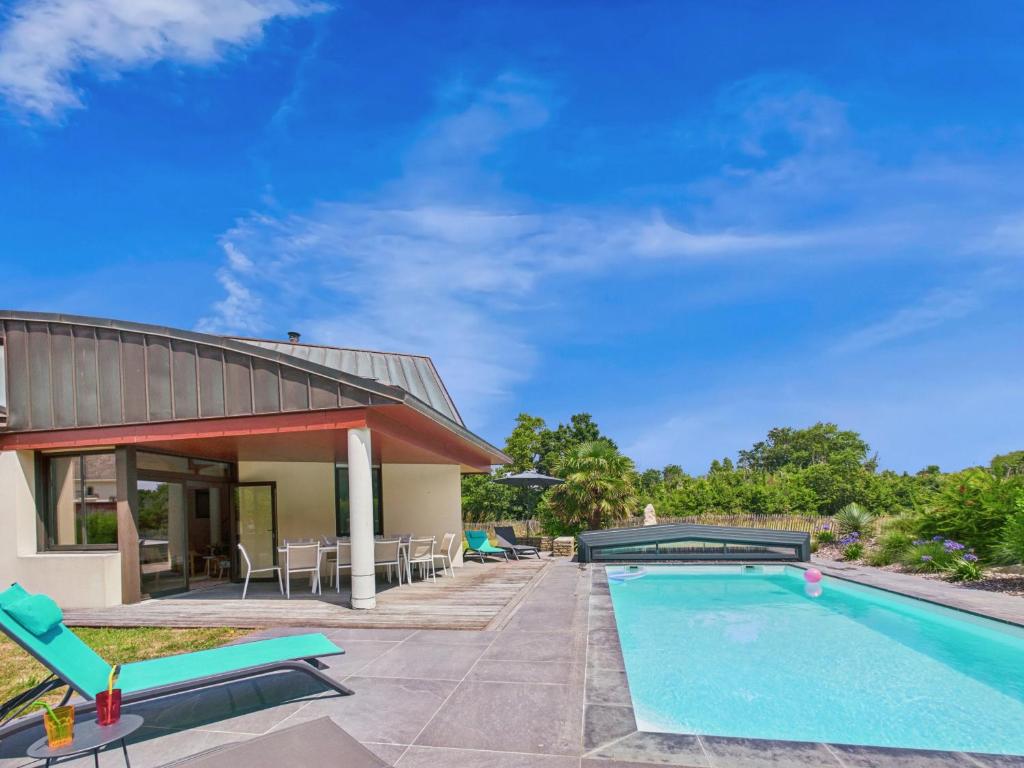 une piscine avec des chaises et une maison dans l'établissement Jardin et piscine - 1km de la plage de Mousterlin, à Fouesnant