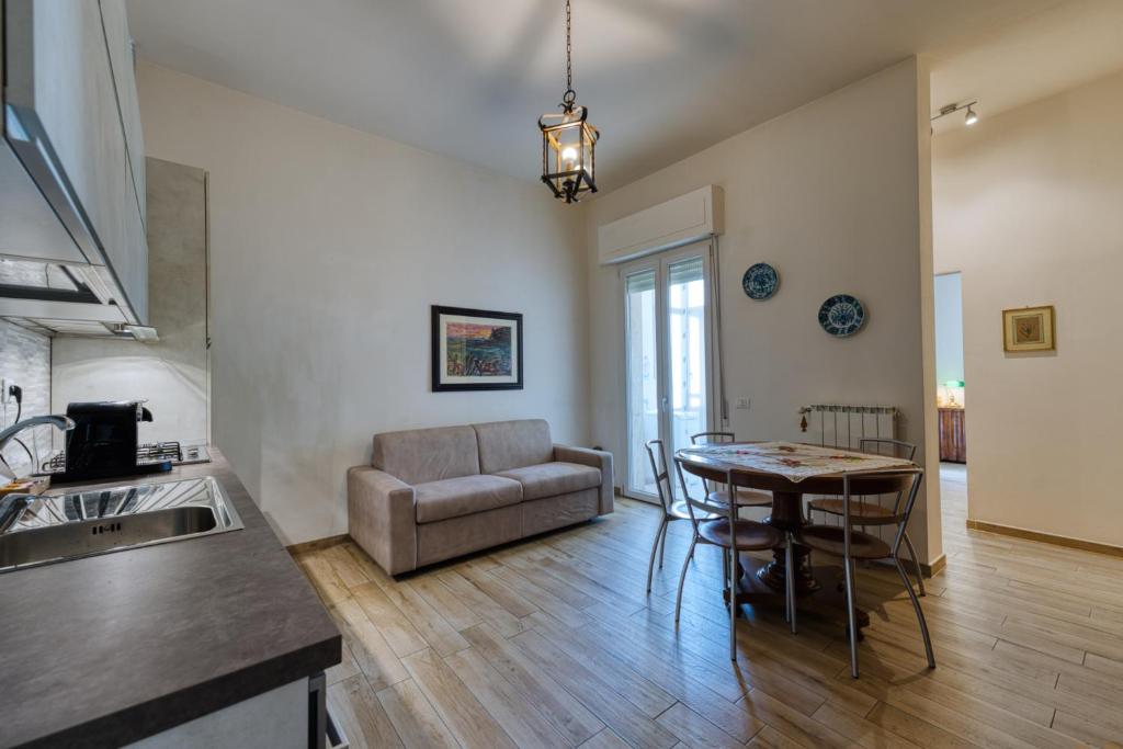 eine Küche und ein Wohnzimmer mit einem Tisch und einer Couch in der Unterkunft Casella - Boutique Home in Florence in Florenz