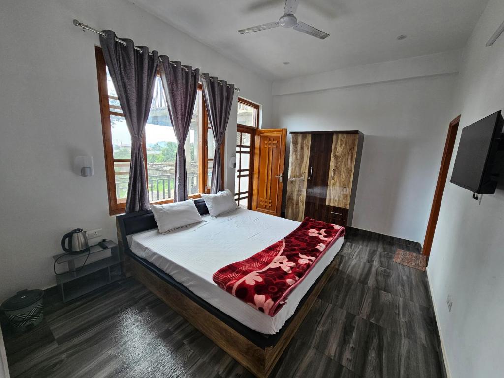 a bedroom with a bed and a large window at HABITAT Holiday Home in Dharmsala
