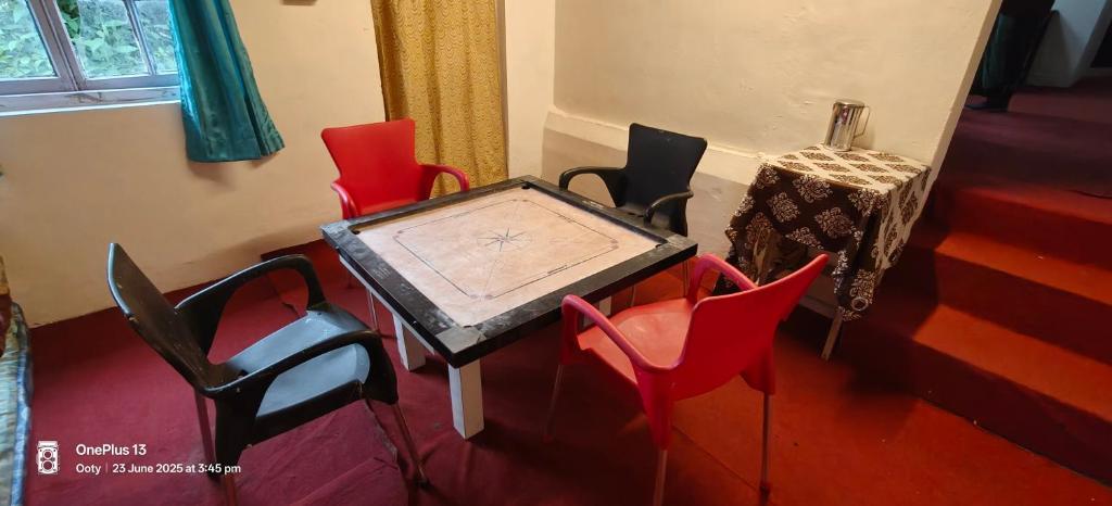 a table and chairs in a room with a table at Nest 'N' Woods in Ooty