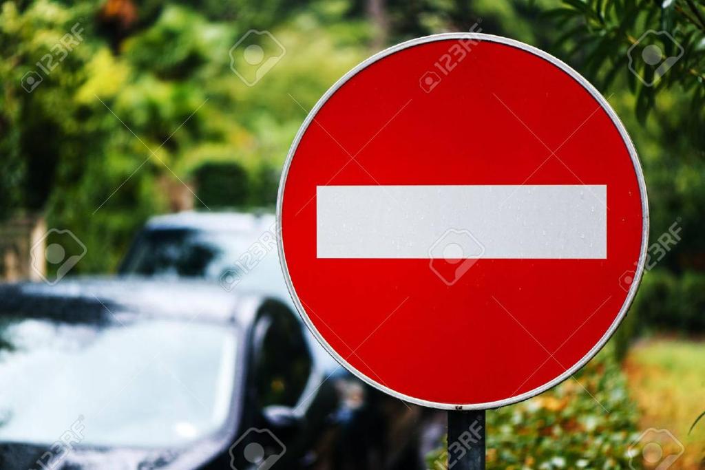 a red and white stop sign with cars in the background at Przytulna kawalerka in Gdynia