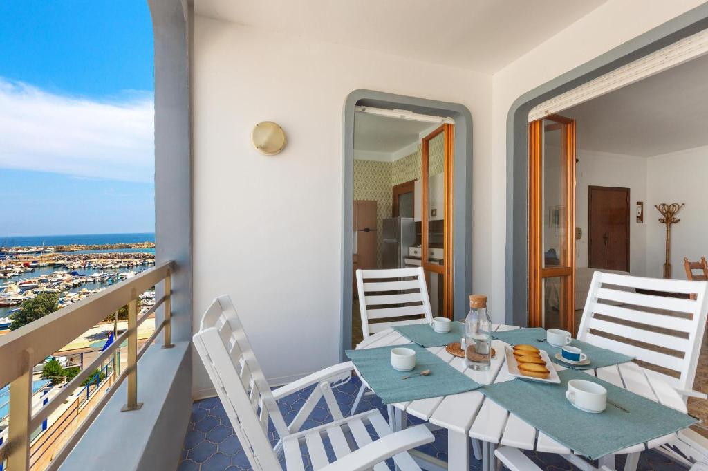 ein Esszimmer mit Tisch und Stühlen auf einem Balkon in der Unterkunft Balconcino Vista Mare by BarbarHouse in San Foca