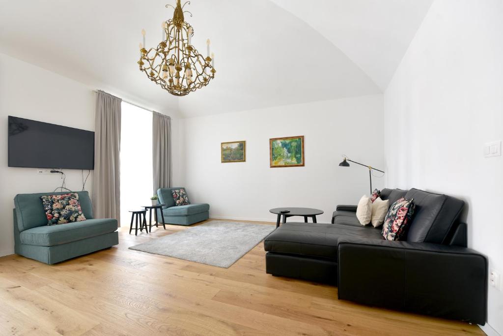 sala de estar con sofá negro y lámpara de araña en Apartmán Palackého Free Parking, en Trenčín
