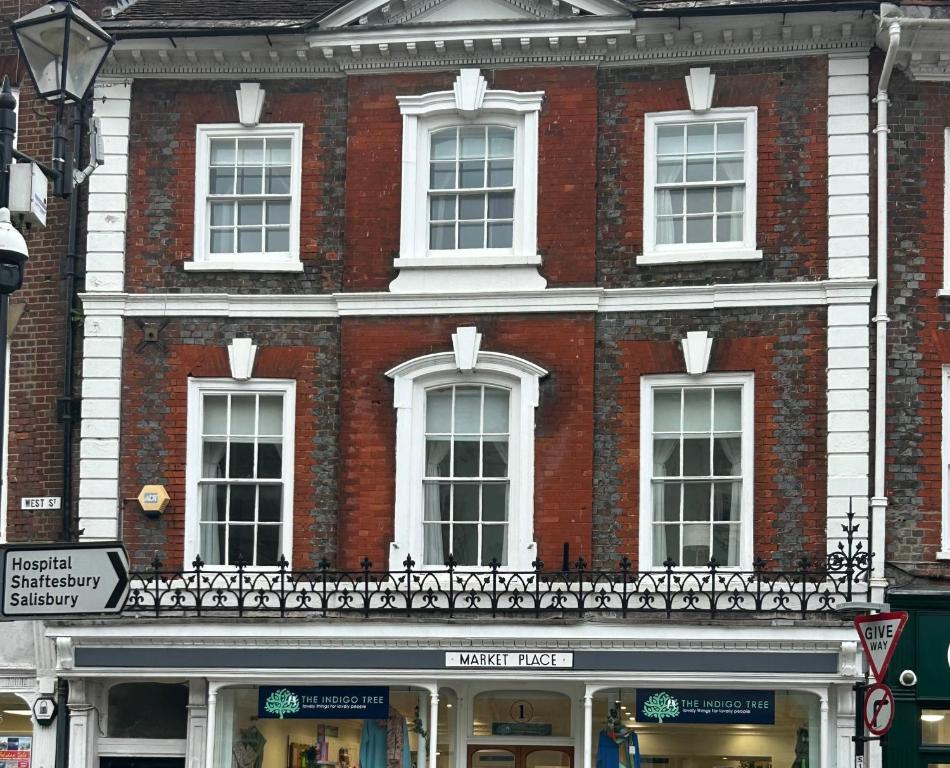 a large brick building with white windows on a street at Single Room in Georgian Masionette in Blandford Forum