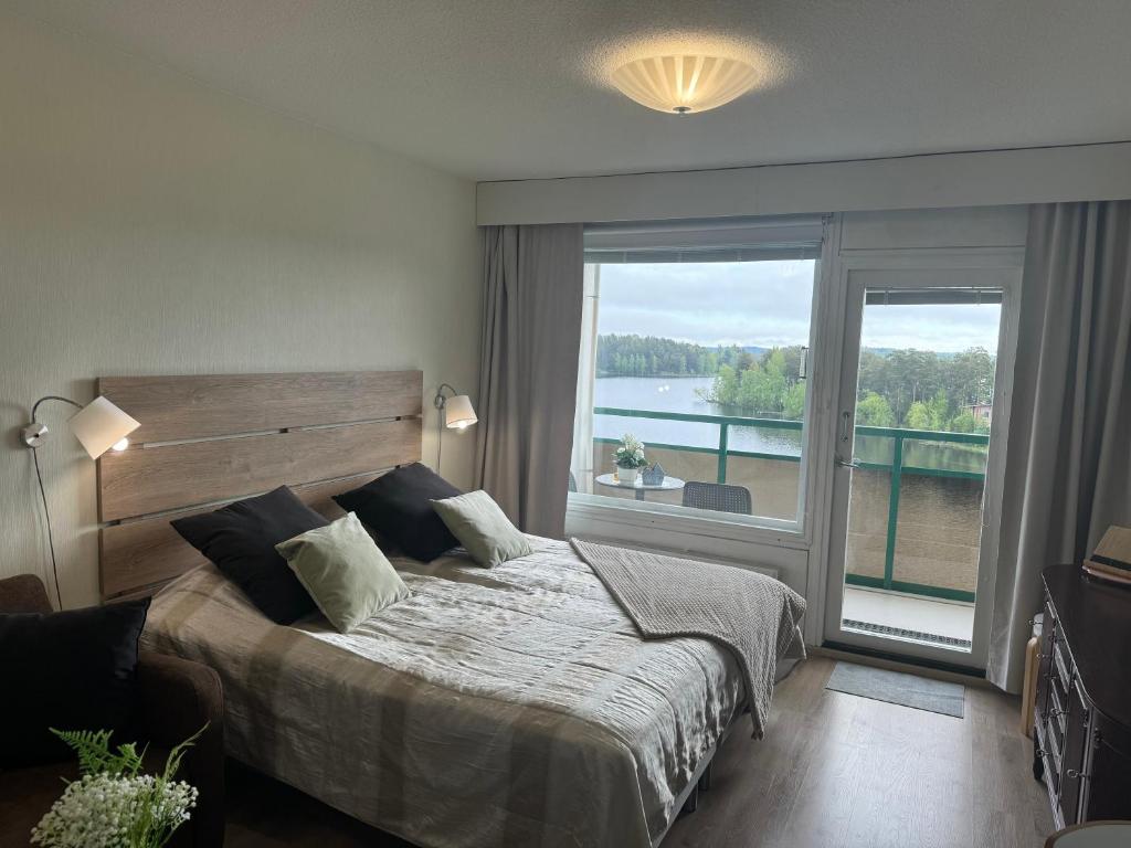 Un dormitorio con una cama y una ventana grande. en Hotelli Terme 616, en Kilvakkala