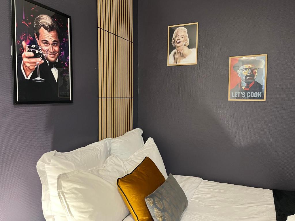 a bedroom with two pictures on the wall and a bed at L'icône du cinéma - Studio cosy - Gare - Centre-ville Evreux - Wifi in Évreux