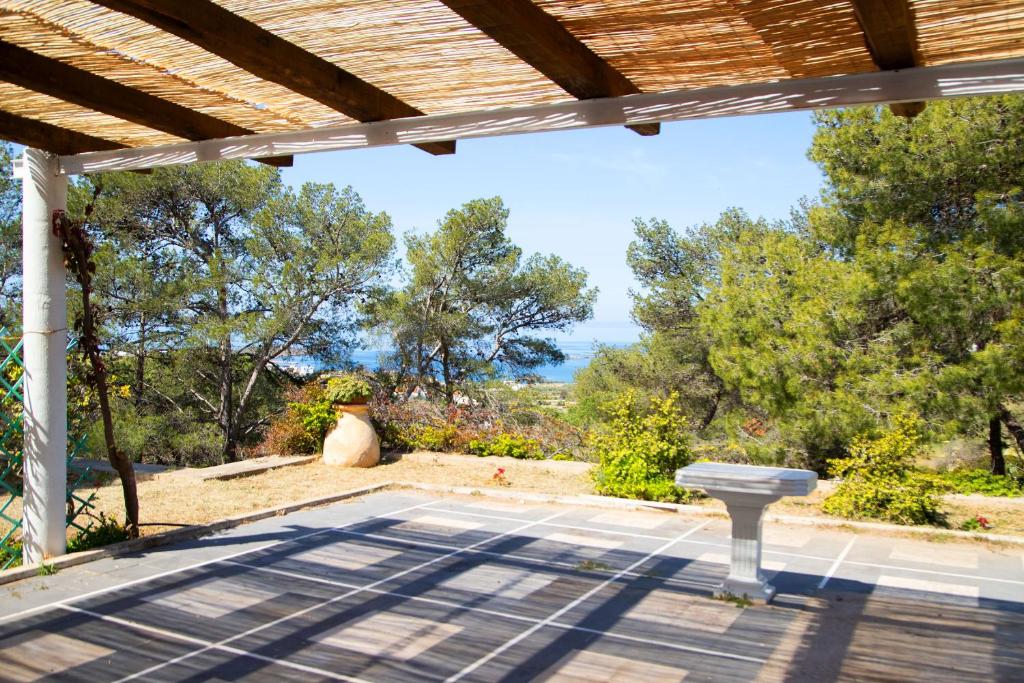 an outdoor patio with a table and a bench at Villa Marina in Posidhonía