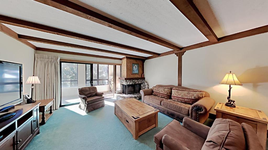 a living room with a couch and a tv at Retro 3 Bed 3 Bath Condo with Mountain View! Steps to Canyon Lodge! Unit 210 at 1849 in Mammoth Lakes