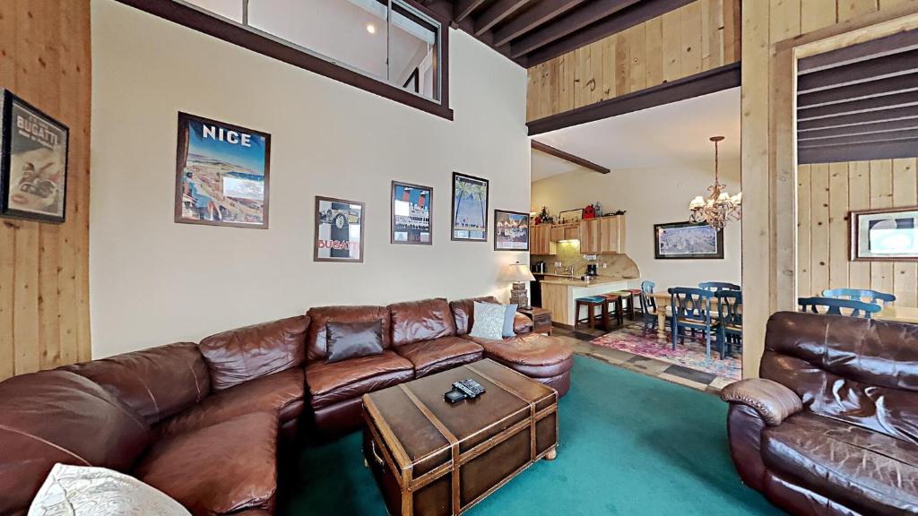 a living room with a leather couch and a table at Beautifully Remodeled 4 Bedroom Condo in Mammoth Lakes