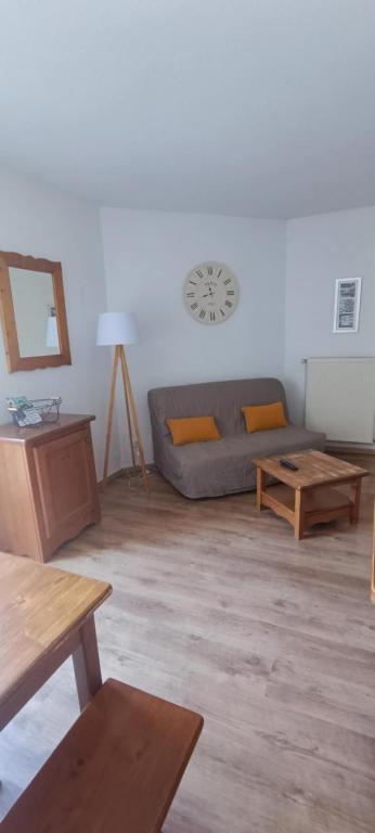 a living room with a couch and wooden tables at Appartement T2 Vue montagne in Cauterets